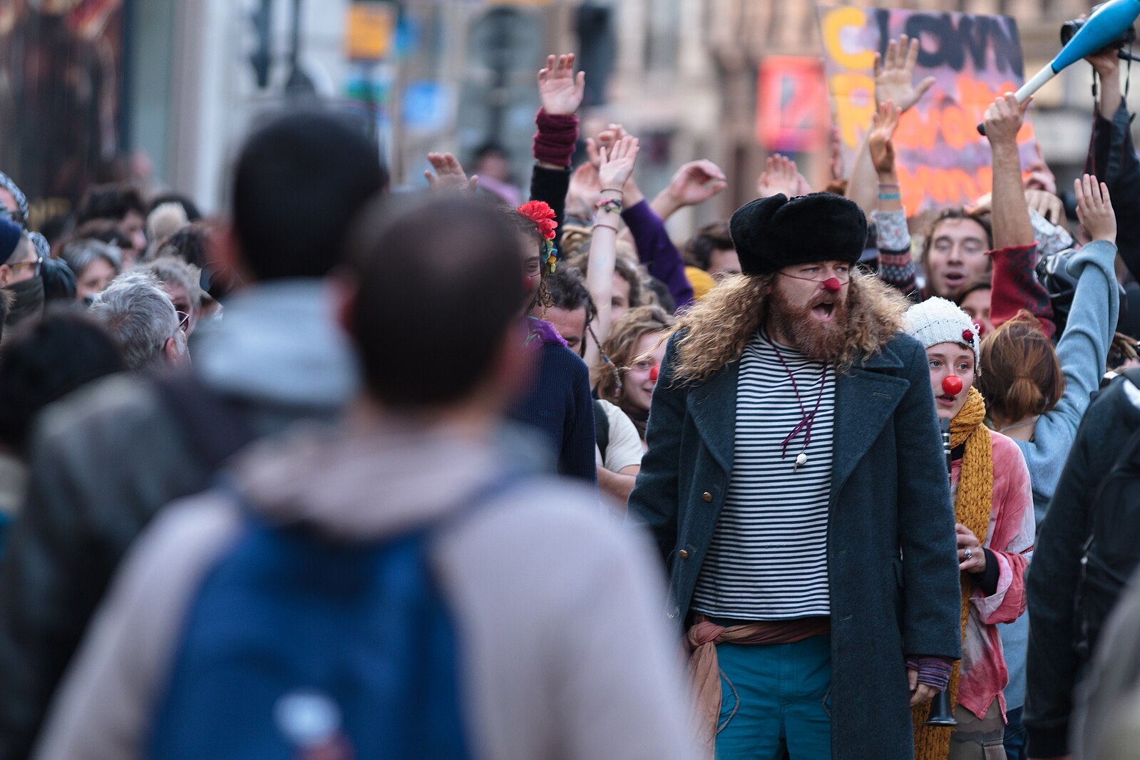 Protestors take to the streets, many wearing clown noses.